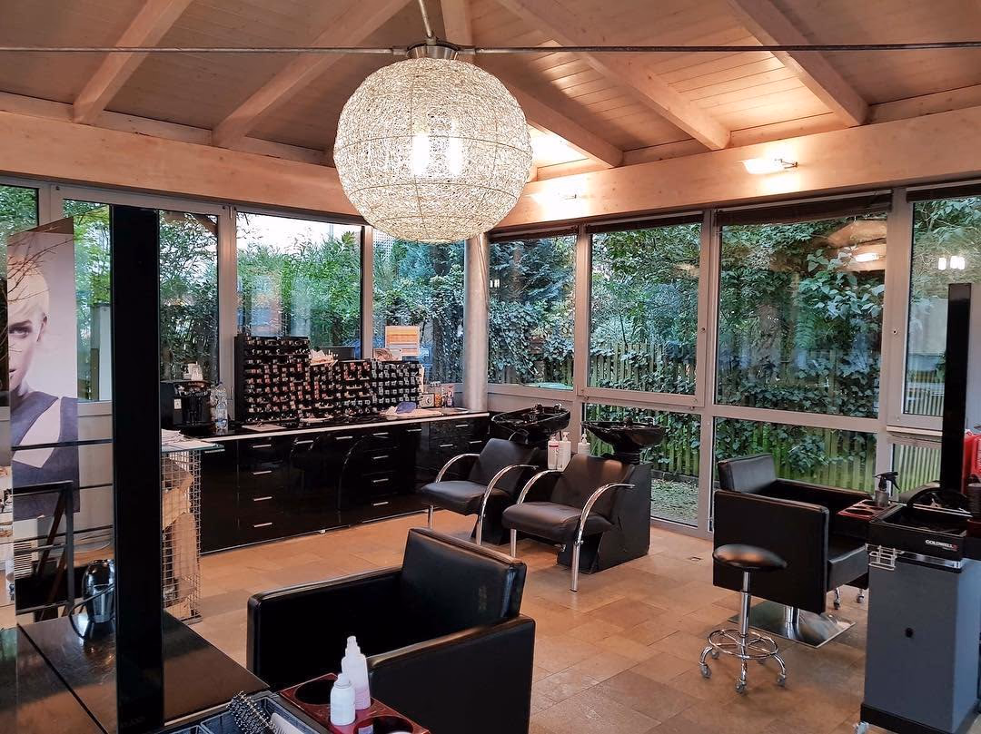 Der Salon Haar Exakt am Abend von innen, mit blauer Lichtleiste und Kugelleuchte